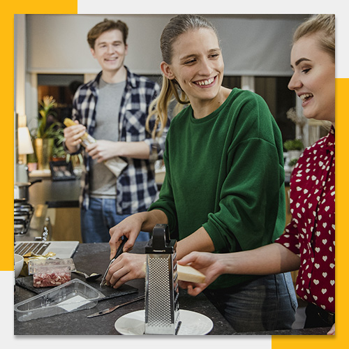 college friends making food in shared kitchen