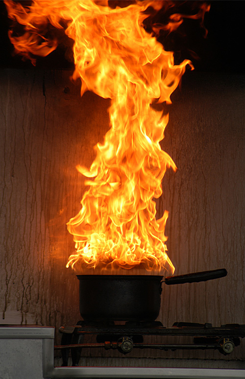 Tall fire out of a kitchen pot on the stove